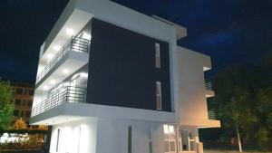 a large white building with lights on it at night at Pensiunea CASID in Eforie Nord