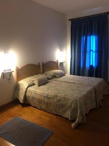 a bedroom with a bed and two lamps and a window at Casa Ferreiro in Seoane