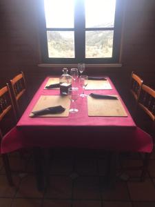 une table avec un tissu de table rose et des verres à vin dans l'établissement Casa Ferreiro, à Seoane