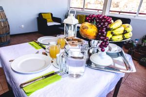 una mesa con un plato de comida y un bol de fruta en Criola Maison en Mindelo