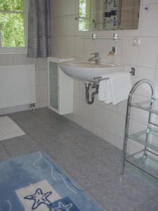 ein Bad mit einem Waschbecken und einem Spiegel in der Unterkunft Ferienhaus Mine Sehnsucht in Dierhagen