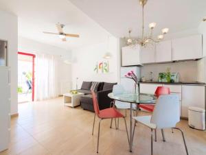 a dining room and living room with a table and chairs at Charming Bungalow in Maspalomas with Shared Pool in Maspalomas