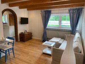 ein Wohnzimmer mit einem Sofa und einem Tisch in der Unterkunft Ferienhaus Anker an der Nordsee in Dornum