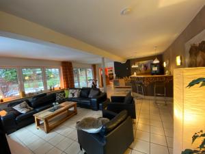 a large living room with couches and a kitchen at Ferienhaus Hirtenwiese in Willingen
