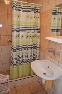 a bathroom with a shower curtain and a sink at Willa Sara' in Władysławowo