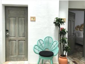 une chaise bleue assise devant une porte dans l'établissement Casapuerta El Refugio, à Zahara de los Atunes
