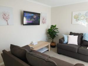 ein Wohnzimmer mit Couch und Tisch in der Unterkunft Rose Apartments Unit 1 Central Rotorua-Accommodation&Spa in Rotorua