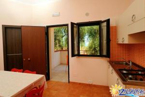 eine Küche mit einem Tisch und einem Fenster in der Unterkunft Zagare Residence in Rodi Garganico