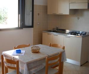 a kitchen with a table and chairs and a table and a table and a kitchen at Zagare Residence in Rodi Garganico