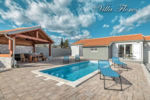 patio z basenem i domem w obiekcie villa flores w mieście Kavran