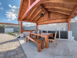 drewniana pergola z drewnianym stołem i ławkami w obiekcie villa flores w mieście Kavran