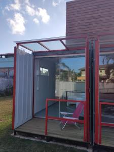 a small building with a table and a chair at Paradise Container Glamping in Florianópolis