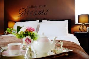 a bed with a tray with a tea set on it at 1FG Dreams Unlimited Serviced Accommodation- Staines - Heathrow in Stanwell