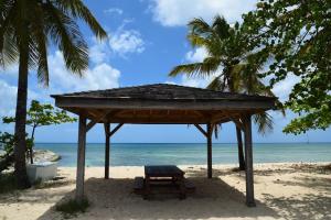 un refugio de picnic en una playa con el océano en Maison créole, côté plage Bel emplacement, en Port-Louis