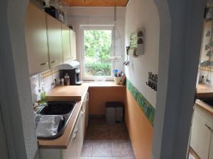 una pequeña cocina con fregadero y ventana en An der Elde mit Boot en Lübz
