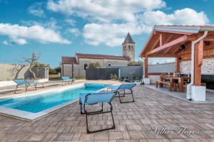 patio z basenem i krzesłami obok budynku w obiekcie villa flores w mieście Kavran