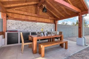 drewniany stół i krzesła na patio w obiekcie villa flores w mieście Kavran