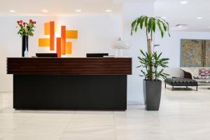 a reception desk in a lobby with plants at Athenaeum Grand Hotel in Athens