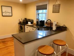 a kitchen with a counter and two stools at Newly Renovated 3BR Hudson Valley House in Ulster Park