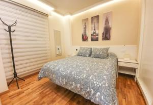 1 dormitorio con 1 cama y algunas fotos en la pared en Burgas Termal, en Ourense