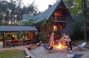 un grupo de personas de pie alrededor de un campamento de fuego en Family Camp Ryczywół - Natura Relaks Spokój, en Ryczywół