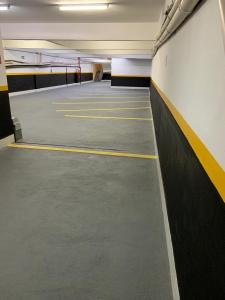 an empty parking lot with yellow and black stripes at QualyLeste Hotel in Caratinga