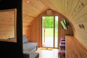- un salon avec un canapé et une grande fenêtre dans l'établissement Cairnfold Cabins, à Kilsyth