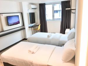 a hotel room with two beds and a tv at TEXAS INN in Sibu