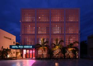 un edificio alto con luces encendidas por la noche en HOTEL PINK HIBISCUS, en Isla Miyako