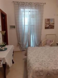 a bedroom with a bed and a table and a window at B&b Gaestehaus Tagaro in Locorotondo