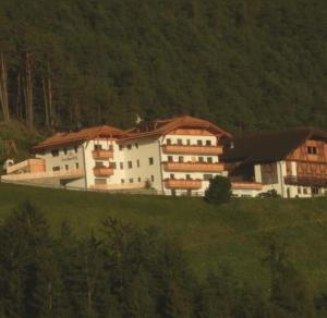 een groot gebouw op een heuvel in een veld bij Forchnerhof -Appartement Dolomitenblick in Rodengo