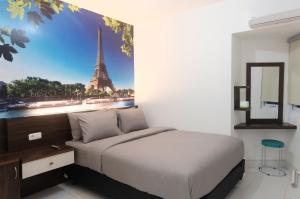 a bedroom with a bed with a picture of the eiffel tower at Green Stay Inn Aeropolis in Tangerang