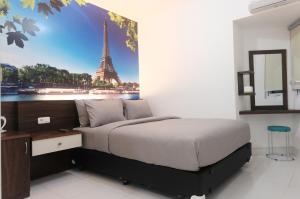 a bedroom with a bed with a picture of the eiffel tower at Green Stay Inn Aeropolis in Tangerang