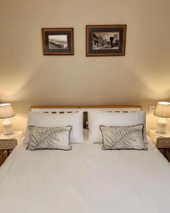 a bedroom with a white bed with two pillows at Tolpuddle Hideaway, Tolpuddle, Dorset in Dorchester