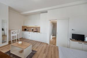 a white room with a bed and a kitchen at Soho apartment in Písek +11 photos