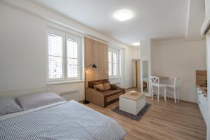 a bedroom with a bed and a couch and a table at Soho apartment in Písek