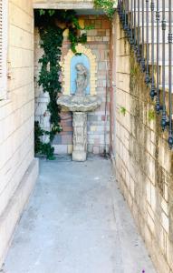 una estatua de piedra sentada en la entrada de un edificio en monaco, CHAMBRE LUXE, à 250M casino en Beausoleil