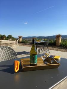 una botella de vino en una bandeja en una mesa con copas en Tenuta il Sassone - Wine&Food en Massa Marittima