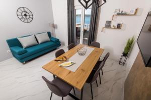 une salle à manger avec une table en bois et un canapé bleu dans l'établissement Euroholiday apartments, à Turanj