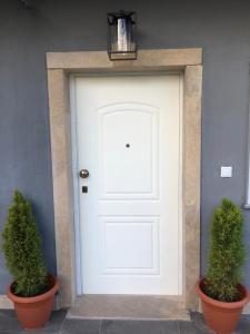 a white door with two potted plants in front of it at Modern House in Afitos