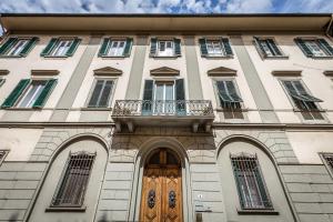 フィレンツェにあるCasa di Barbanoの木製のドアとバルコニー付きの建物