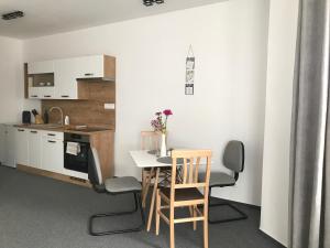 a kitchen with a table and chairs in a room at Maja Apartmán č 4 in Bešeňová