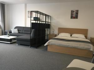 - une chambre avec un lit et un canapé dans l'établissement Maja Apartmán č 4, à Bešeňová
