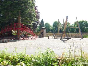 a playground with two swings and a red slide at Rondeva in Chester