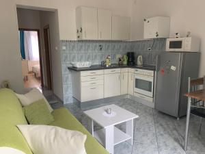 a kitchen with a couch and a table in a room at Apartmani Spomenka in Seline