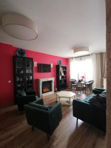 a living room with red walls and a fireplace at Posada del Herrero in Madridejos