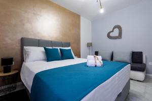een slaapkamer met een groot bed met blauwe en witte kussens bij Euroholiday apartments in Turanj