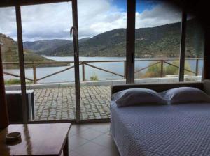 1 dormitorio con cama y vistas al lago en Moradias Douro Internacional en Freixo de Espada à Cinta
