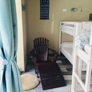 Cette chambre comprend un fauteuil à bascule et deux lits superposés. dans l'établissement Oli Vita Hostel ALBERGUE CON ENCANTO, à Viveiro