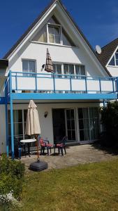 een huis met een tafel en een paraplu ervoor bij Strandzauber in Breege